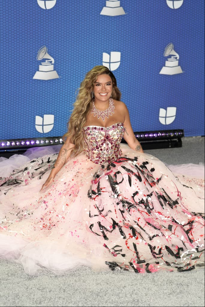 Una de las cantantes más populares de la actualidad es, sin duda, Karol G, quien llegó con un vestido amplio en tono rosa y cuya falda parecía estar grafiteada.