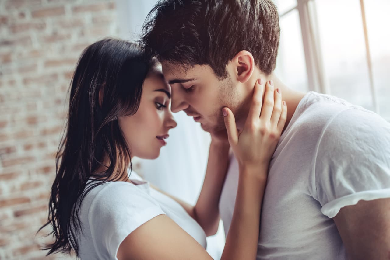 Beautiful young couple at home. Hugging, kissing and enjoying spending time together.