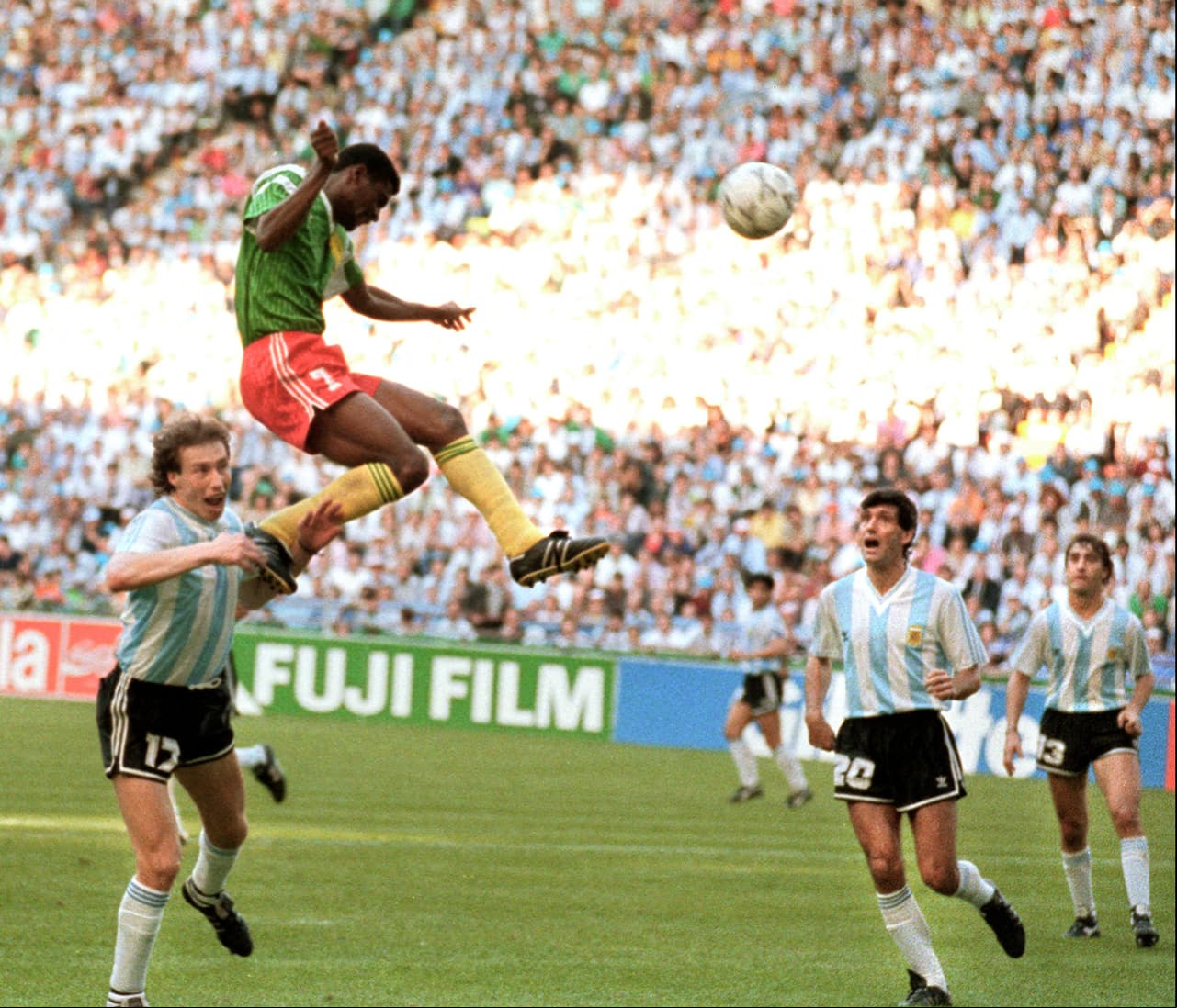 Forward Francois Omam-Biyick from Cameroon scores on a header as Argentinian defenders Nestor Lorenzo (L) and Juan Simon look on 08 June 1990 in Milan during the World Cup opening match between Cameroon and Argentina. Despite two expulsions, Cameroon upset the defending World champions 1-0. AFP PHOTO (Photo by STAFF / AFP) (Photo by STAFF/AFP via Getty Images)