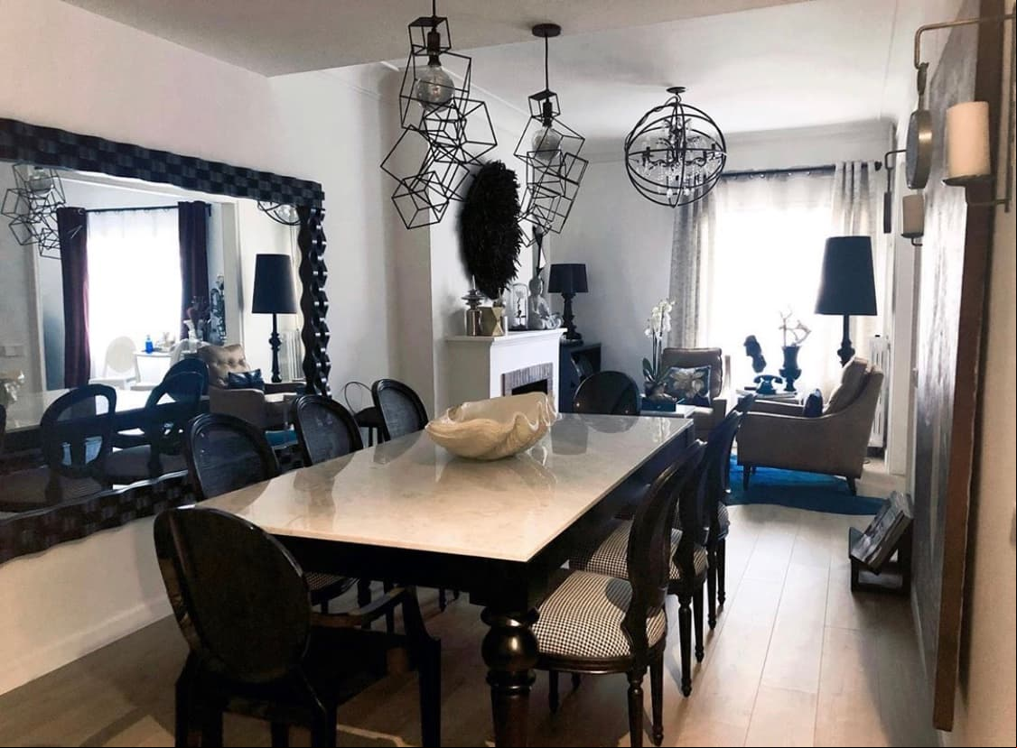 En cuanto al comedor, el negro de las sillas con las patas del inmueble del mismo tono contrastan con la cubierta de la mesa de mármol en color blanco.