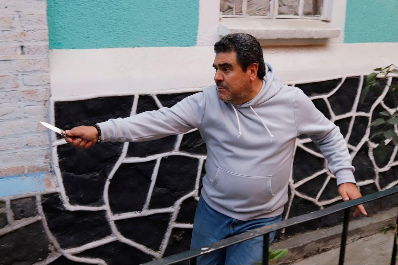 Con cuchillo en mano, El Bacalao persigue a Luchita para matarla por haberle robado su dinero.