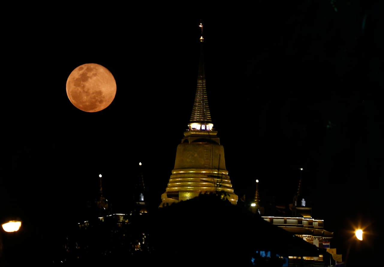 Una súper luna rosa se eleva sobre el Templo Wat Saket, o el Monte Dorado en Bangkok.