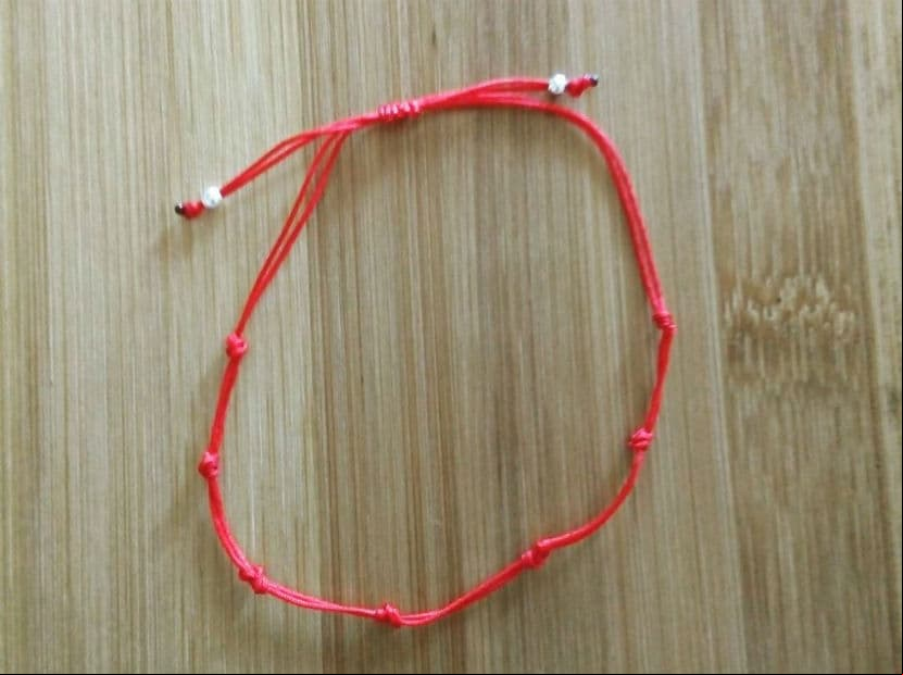 Una pulsera de cordón rojo con siete nudos es un amuleto popular para protegerte