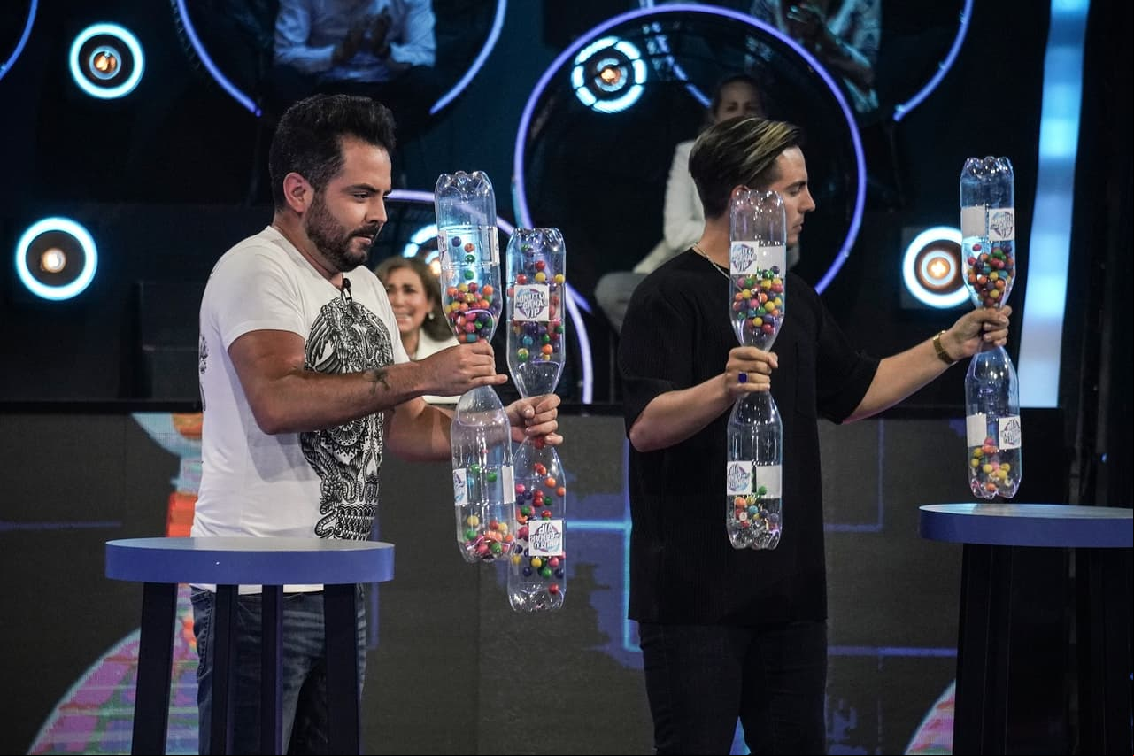 La primera prueba a la que se enfrentaron los hermanos Derbez fue ‘La Sonaja’, reto en el que tuvieron que agitar un par de botellas con chicles en esfera para que pasara por el pequeño orificio de otra en menos de un minuto, ganando los primeros 50 mil pesos para la causa.