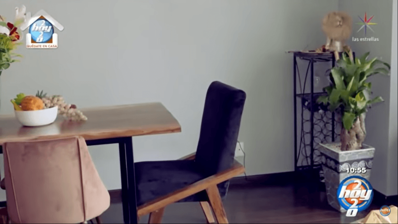 El comedor tiene una mesa del mismo tono que los gabinetes y varias sillas aterciopeladas en tonos morado y rosa; además en una esquina hay varias plantas.